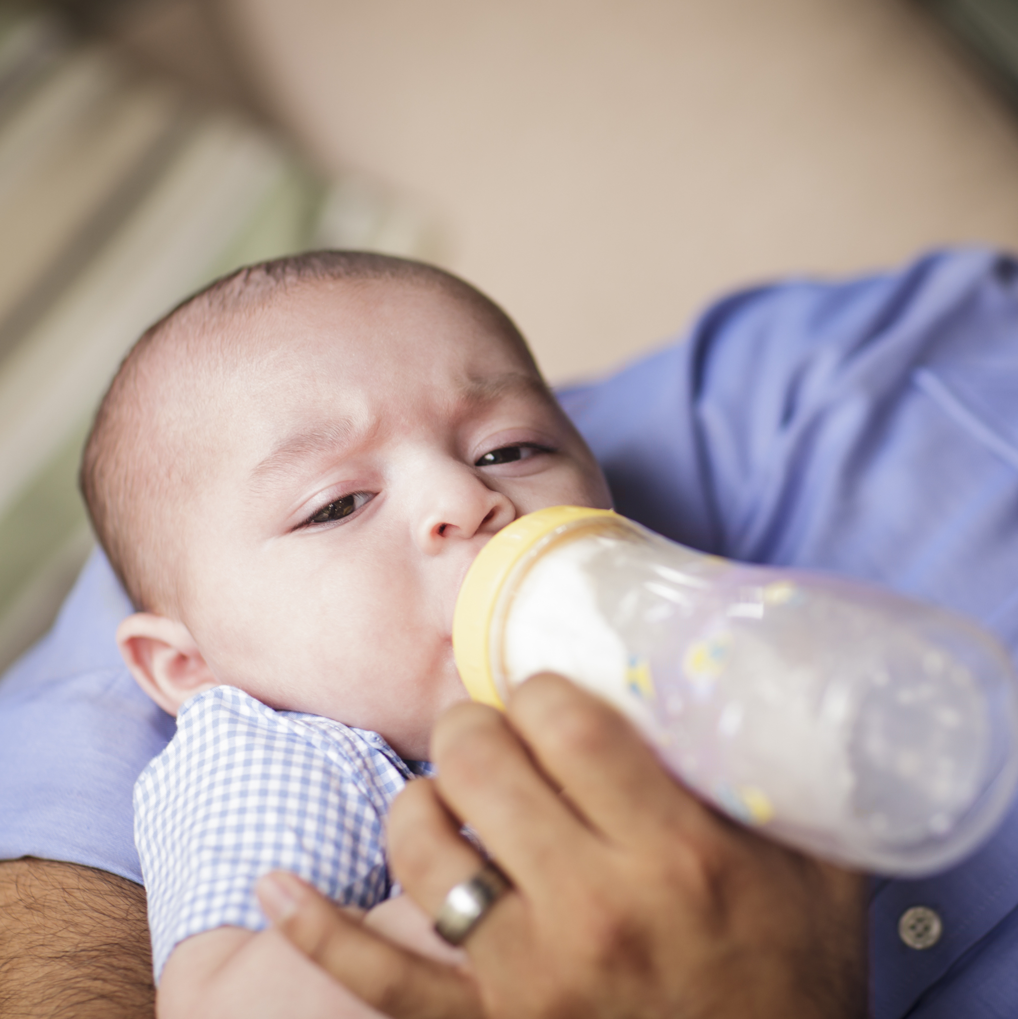infant bottle feeding with grimace