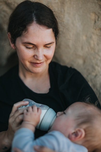 woman bottle feeding infant